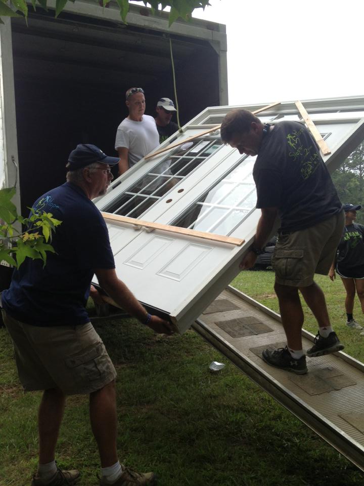 Members at renovation site holding supplies